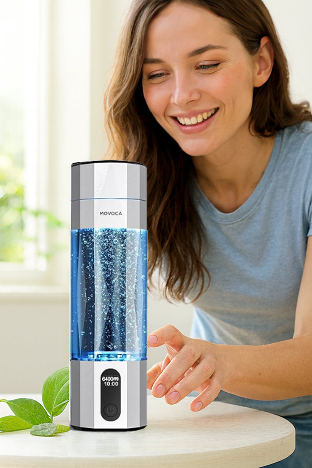 Woman smiling and reaching for a MOVOCA hydrogen water bottle on a table, with swirling blue water, bright natural light, and a clean wellness setting.